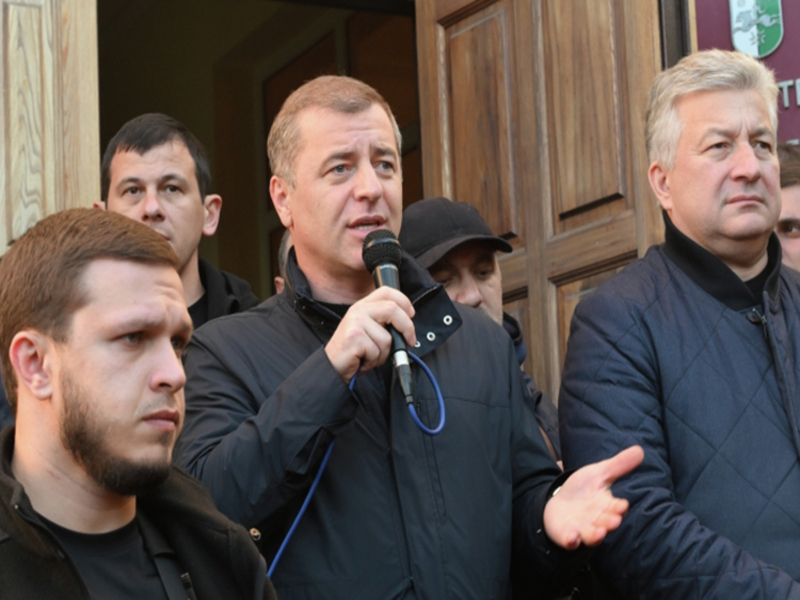 8806808 17.11.2024 Лидер оппозиции Адгур Ардзинба (в центре) выступает перед сторонниками у здания администрации президента Абхазии в Сухуме. Справа: глава комитета по защите суверенитета Абхазии Леван Микаа. 15 ноября парламент должен был рассмотреть вопрос о ратификации соглашения с Россией по инвестиционной политике. Заседание не состоялось из-за акции протеста, сторонники оппозиции сломали забор вокруг комплекса правительственных зданий и заняли здания парламента и администрации президента. Оппозиция потребовала от президента уйти в отставку. Глава государства Аслан Бжания согласен уйти в отставку, если оппозиция покинет захваченные здания, протестующие отвергли предложение властей. Илья Питалев / РИА Новости